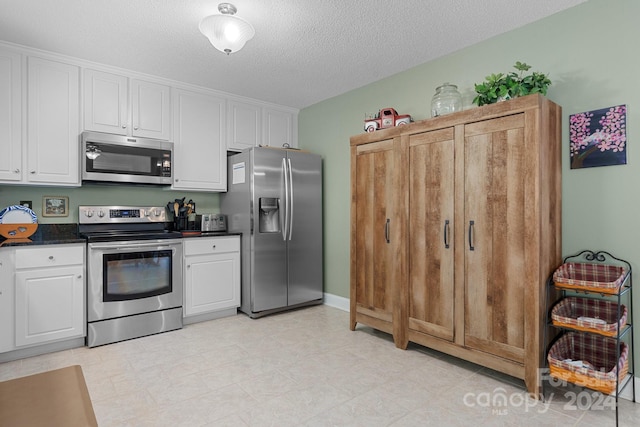 kitchen featuring white cabinets, a textured ceiling, and stainless steel appliances