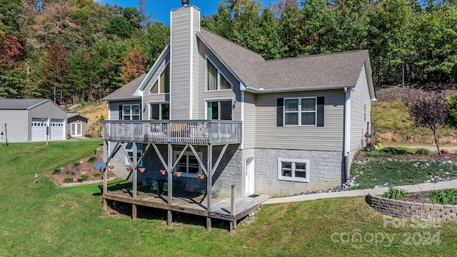 back of house featuring an outbuilding, a deck, a yard, and a garage