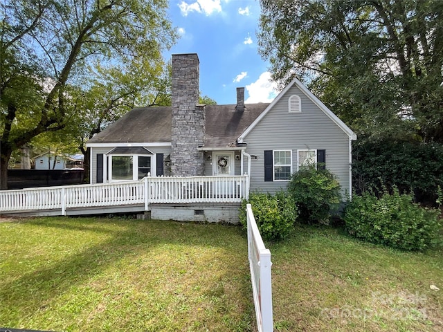 rear view of house with a wooden deck and a lawn