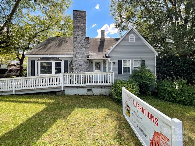 back of house with a lawn and a deck