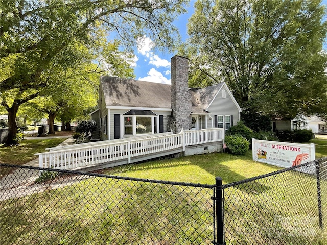 rear view of property featuring a lawn and a deck