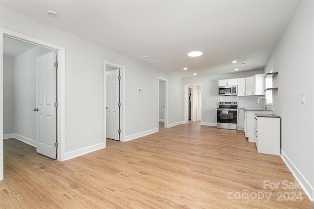 unfurnished living room featuring light hardwood / wood-style floors and sink