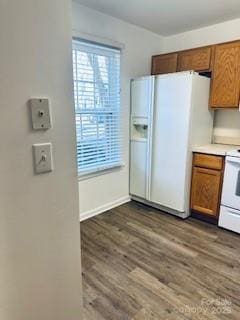 kitchen featuring white fridge with ice dispenser, range, and dark hardwood / wood-style floors