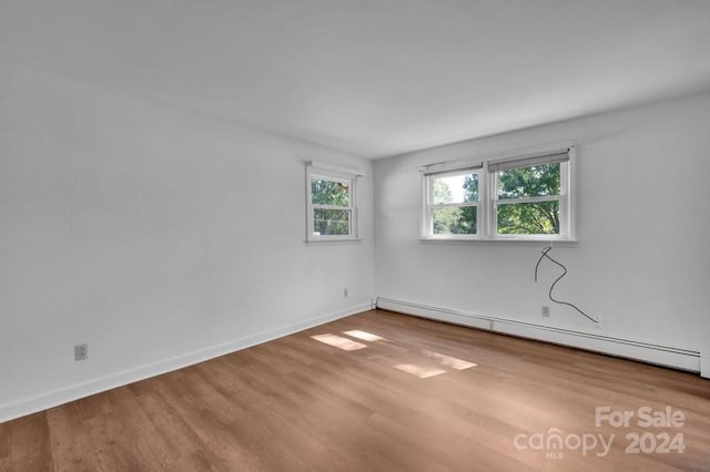 spare room with a baseboard radiator and wood-type flooring