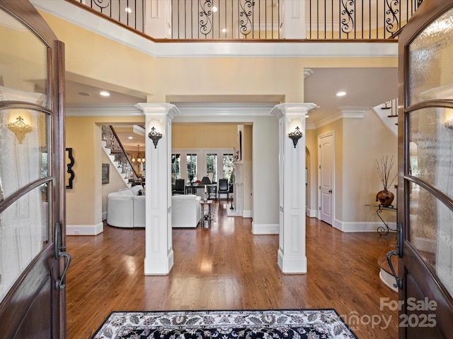 entryway featuring ornate columns, dark hardwood / wood-style flooring, crown molding, and french doors