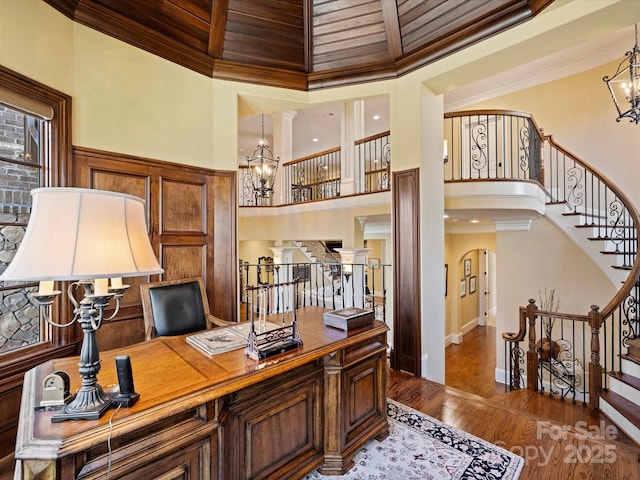 office area featuring wooden ceiling, a high ceiling, beam ceiling, and a notable chandelier