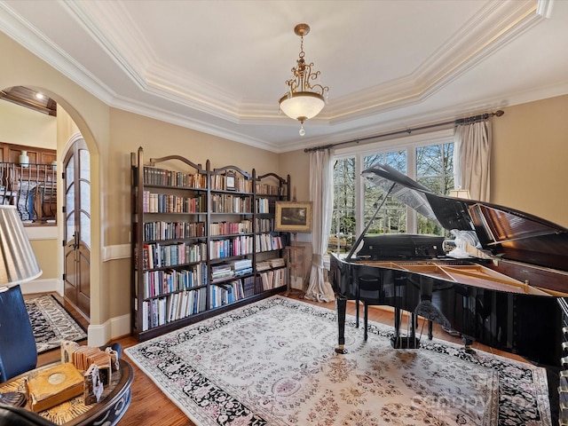 misc room featuring ornamental molding, hardwood / wood-style flooring, and a tray ceiling