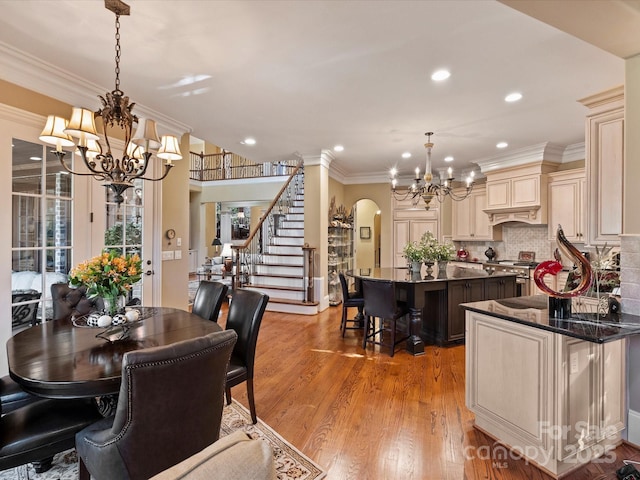 dining room featuring ornamental molding, a notable chandelier, and light wood-type flooring