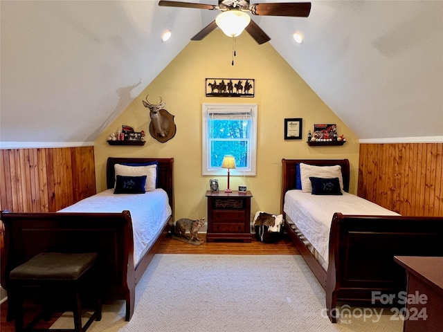 bedroom featuring lofted ceiling and wood walls