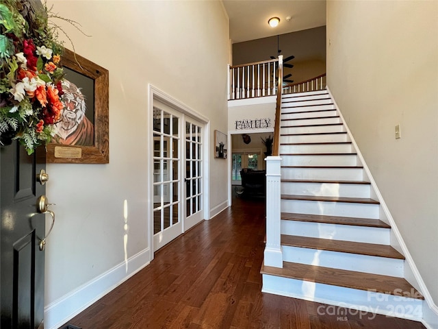 stairway featuring wood-type flooring, french doors, a high ceiling, and ceiling fan