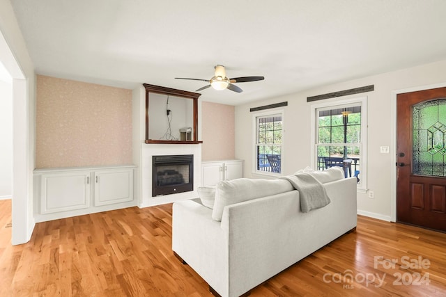 living room featuring light hardwood / wood-style flooring and ceiling fan