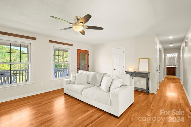 living room with light hardwood / wood-style flooring and ceiling fan