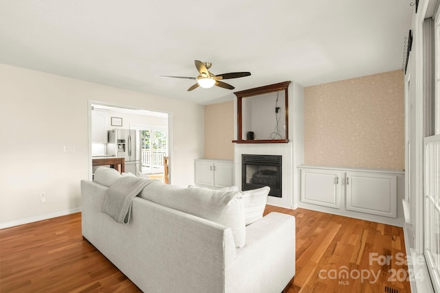 living room with light hardwood / wood-style floors and ceiling fan