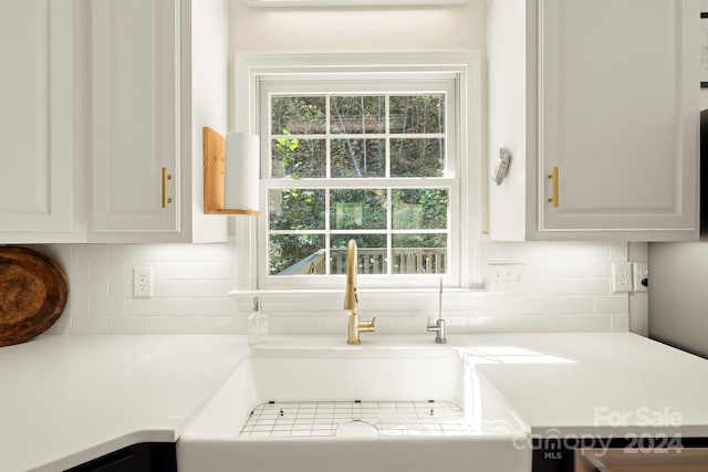 kitchen with sink, white cabinetry, and tasteful backsplash