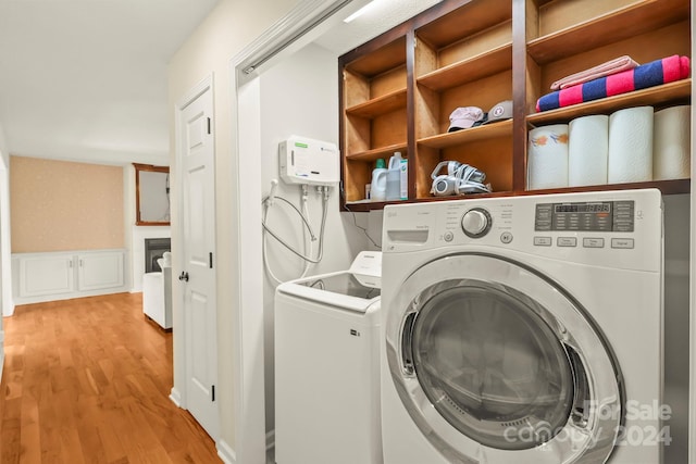 clothes washing area featuring light hardwood / wood-style floors and washer and dryer