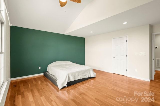 bedroom with wood-type flooring, vaulted ceiling, and ceiling fan