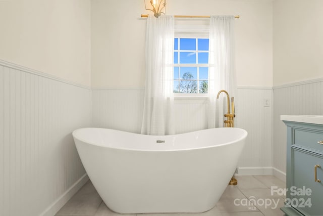 bathroom with vanity, tile patterned flooring, and a washtub