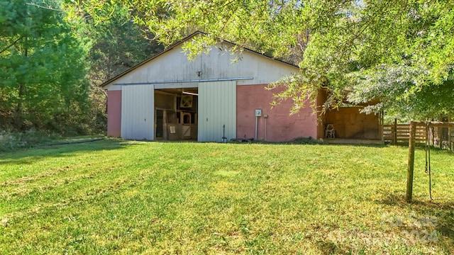 rear view of property featuring a lawn and an outbuilding