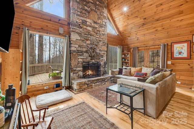 living room with wooden walls, wood finished floors, and a wealth of natural light