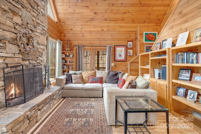 living area with wood walls, a fireplace, and wood ceiling