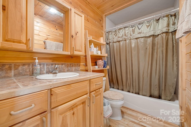 full bath with vanity, wood finished floors, shower / bath combination with curtain, wood walls, and toilet