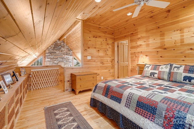 bedroom with lofted ceiling with beams, wood finished floors, wooden walls, wood ceiling, and ceiling fan