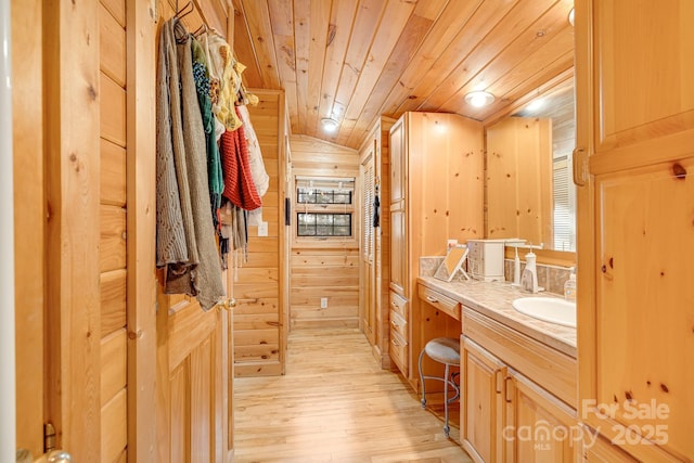 bathroom with wood walls, wooden ceiling, vanity, and wood finished floors