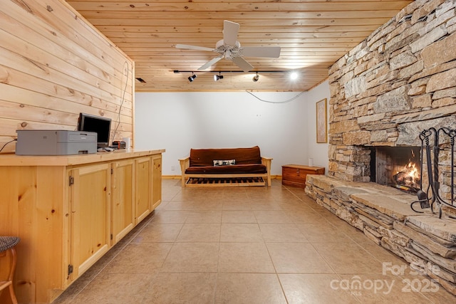 living room featuring light tile patterned floors, wood ceiling, rail lighting, and a fireplace