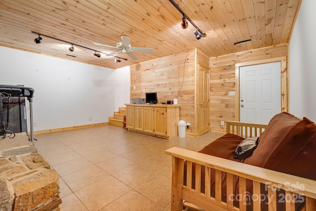 living area featuring light tile patterned floors, wooden walls, wood ceiling, and track lighting