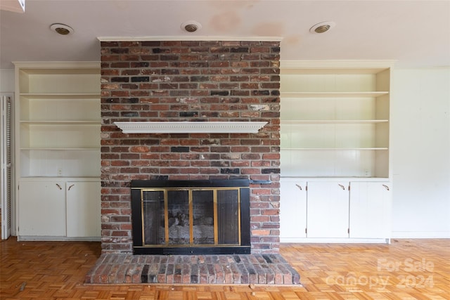 details featuring parquet flooring, crown molding, built in features, and a brick fireplace