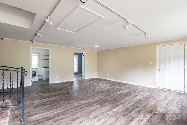 unfurnished living room with washer / dryer, ornamental molding, dark hardwood / wood-style floors, and rail lighting