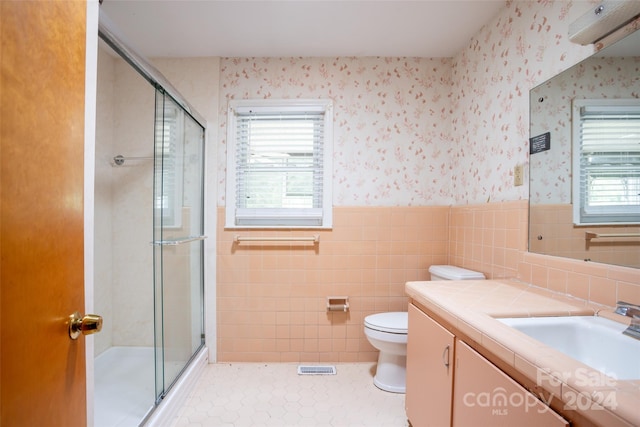 bathroom with vanity, toilet, tile patterned flooring, and an enclosed shower