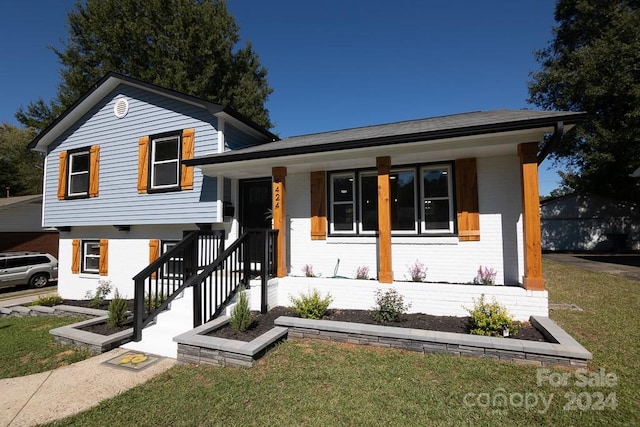 view of front of home with a porch and a front lawn