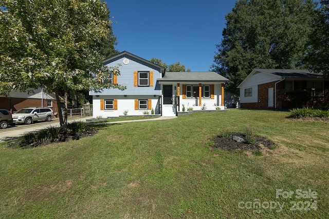 split level home featuring a front lawn and covered porch