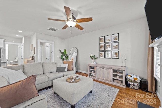 living room featuring light hardwood / wood-style floors and ceiling fan