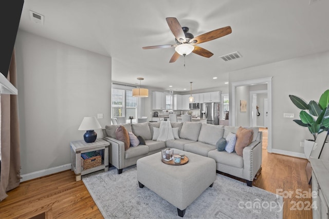 living room with ceiling fan and light hardwood / wood-style floors