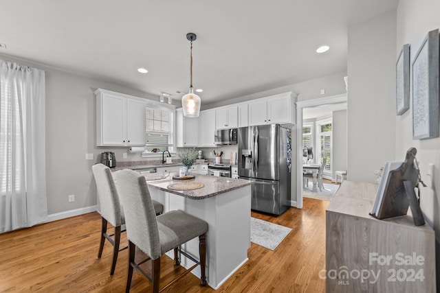 kitchen with sink, light hardwood / wood-style flooring, stainless steel appliances, and white cabinets