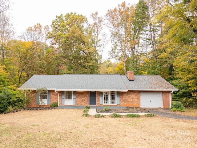 ranch-style house with a front yard, a garage, and covered porch