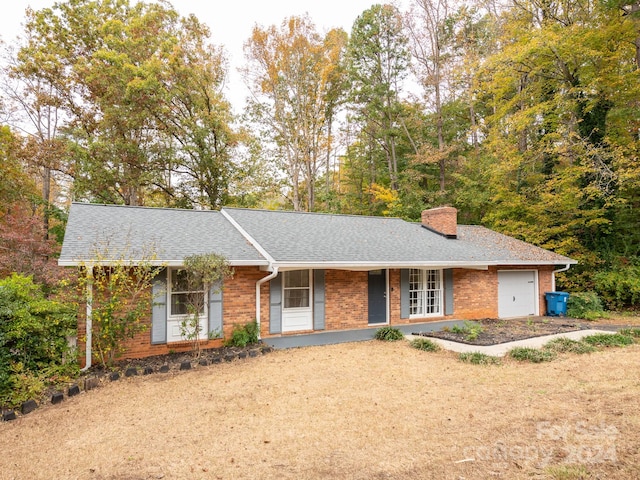 ranch-style home featuring covered porch and a garage