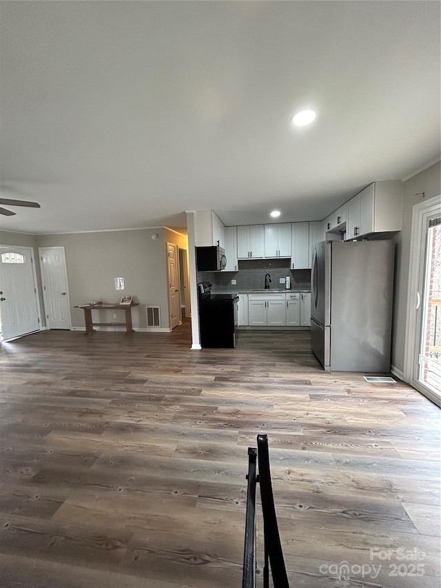 kitchen featuring sink, ceiling fan, hardwood / wood-style floors, stainless steel appliances, and white cabinets