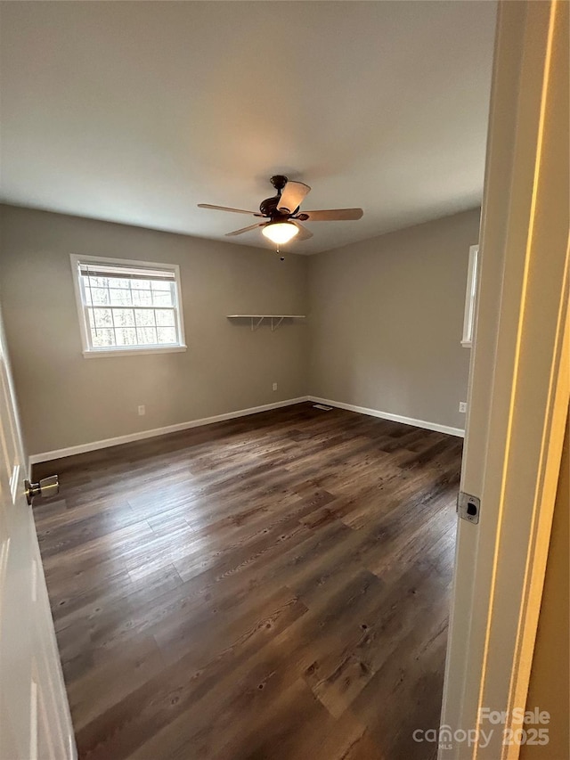 unfurnished room featuring dark wood-type flooring and ceiling fan