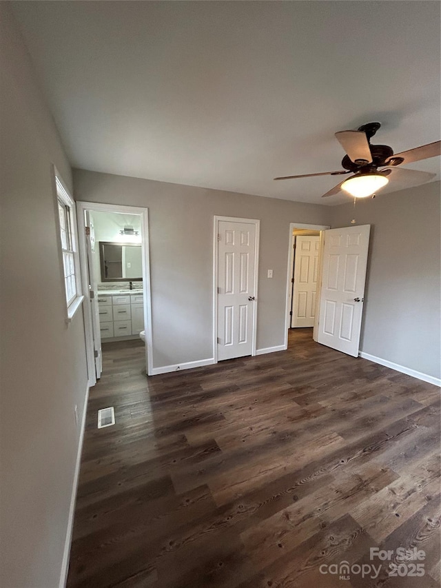 unfurnished bedroom with dark hardwood / wood-style floors, connected bathroom, ceiling fan, and a closet