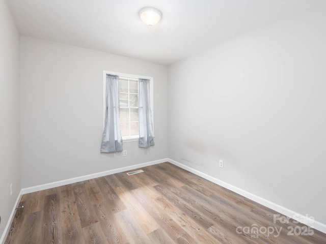 spare room with wood-type flooring