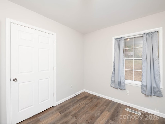 unfurnished room with dark hardwood / wood-style flooring