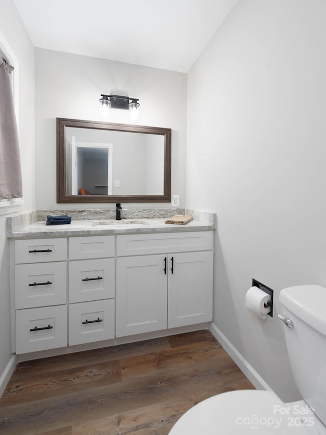 bathroom featuring vanity, toilet, and wood-type flooring