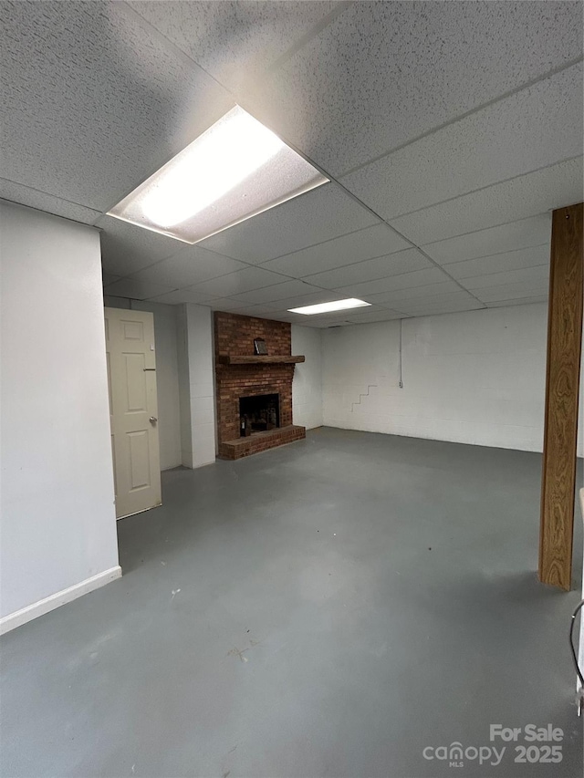 basement featuring a drop ceiling and a fireplace