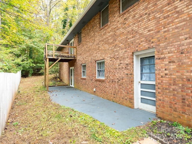 view of side of home featuring a wooden deck and a patio