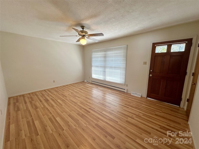 entrance foyer with light hardwood / wood-style flooring, a baseboard heating unit, a textured ceiling, and ceiling fan