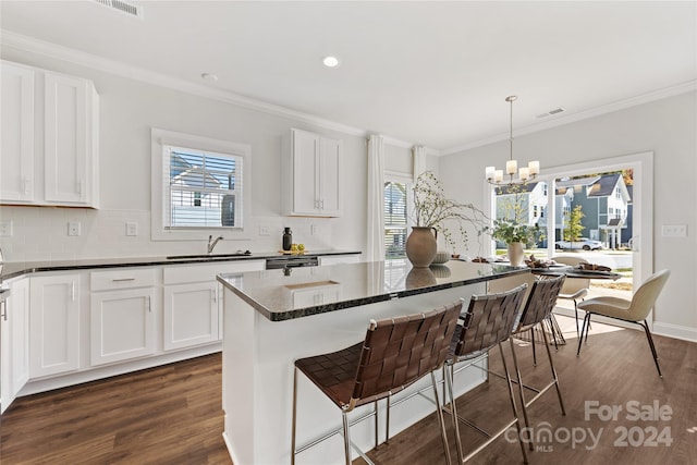 kitchen featuring sink, white cabinetry, hanging light fixtures, and dark wood-type flooring