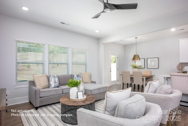 living room featuring hardwood / wood-style floors and ceiling fan